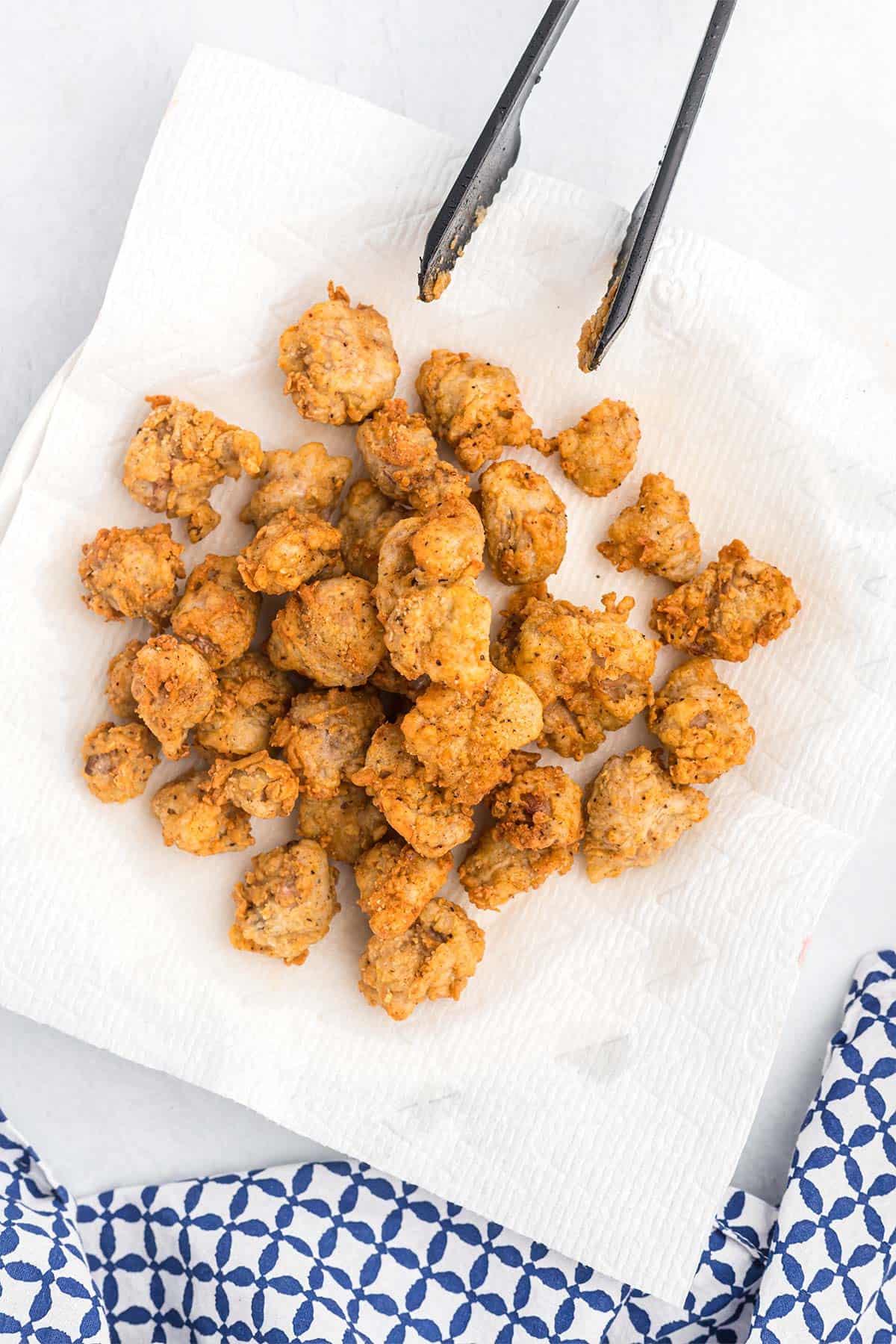 Fried chicken gizzards draining on a paper towel