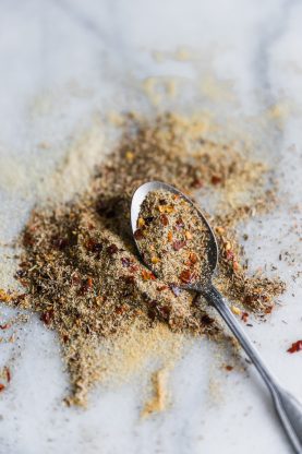 Close up of jerk seasoning with a spoon on a marble background