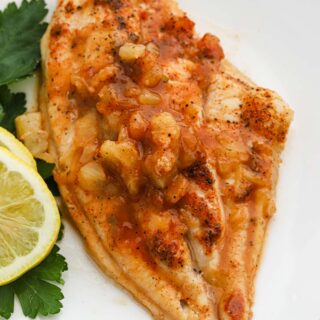 Pineapple Honey Bourbon Grilled Catfish Recipe on a white plate with lemon
