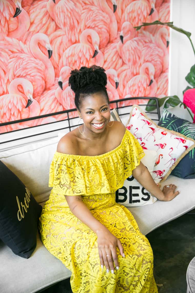 Jocelyn seated on a couch in the lobby area of the 1 Hotel South Beach wearing a yellow outfit