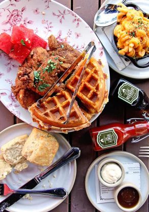 Overhead shot of chicken and waffles, mac and cheese and biscuits at Yardbird in Miami, FL