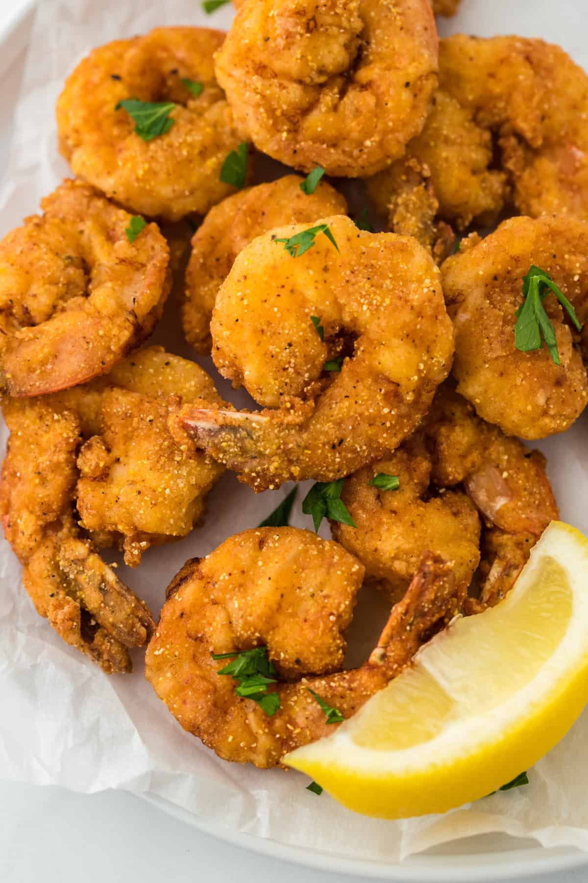 Southern Fried shrimp on a white platter with a lemon wedge ready to enjoy