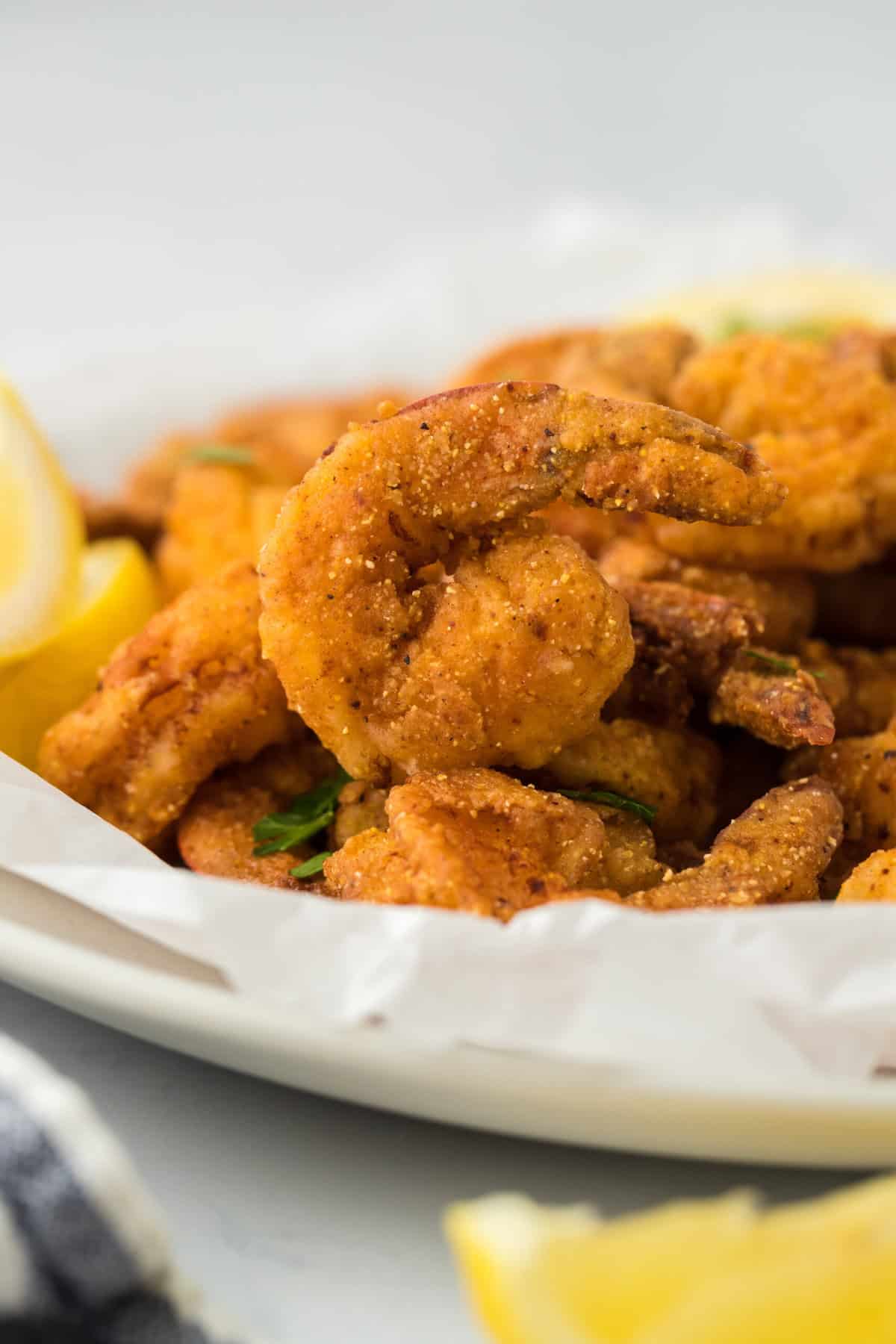 A close up of a fried shrimp recipe on a white plate ready to serve