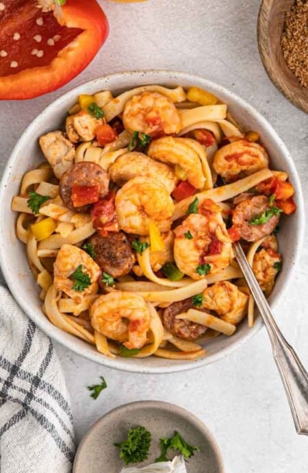 Cajun jambalaya pasta served up in a bowl on the table with a fork in the bowl.