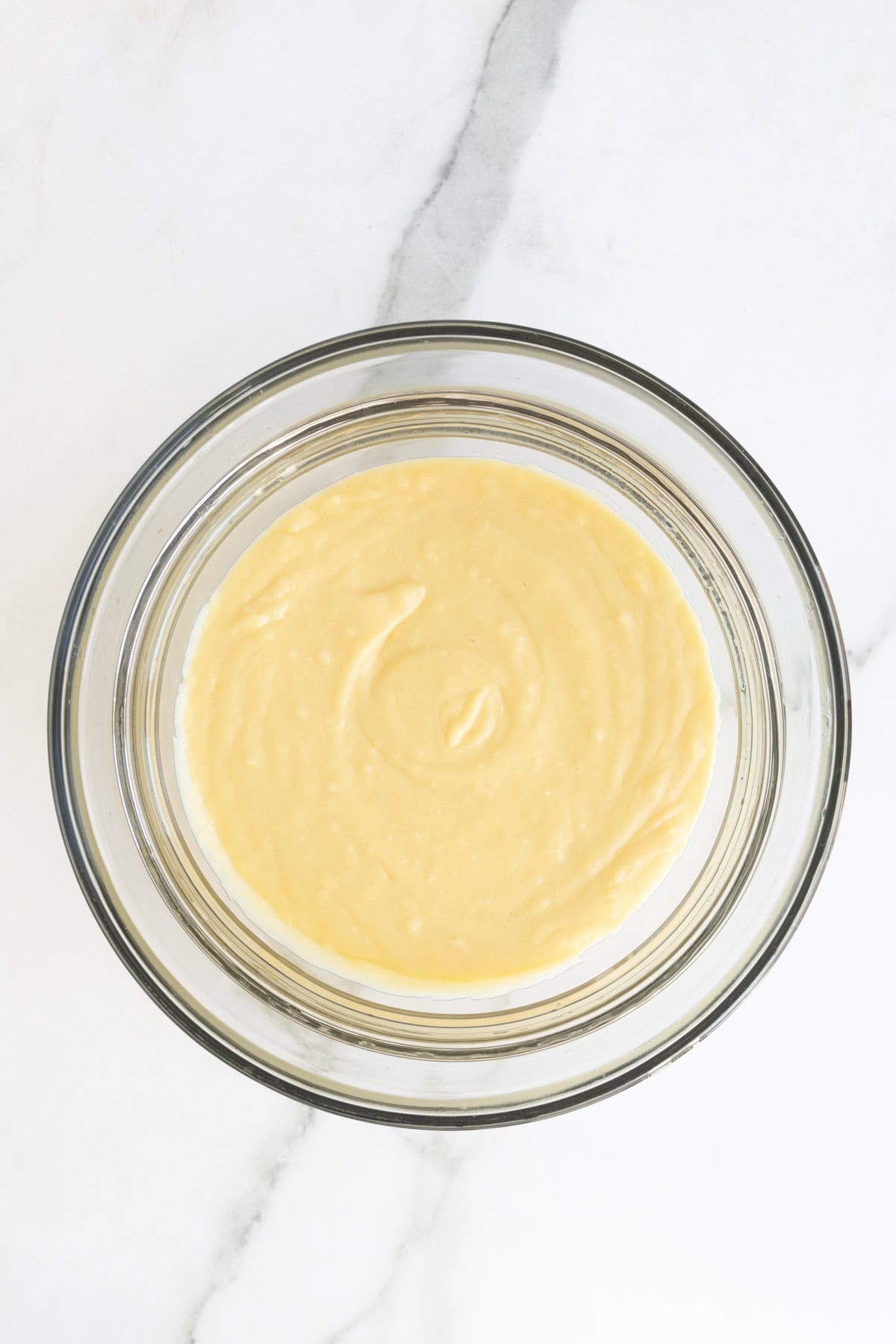 Smooth custard in a clear glass bowl