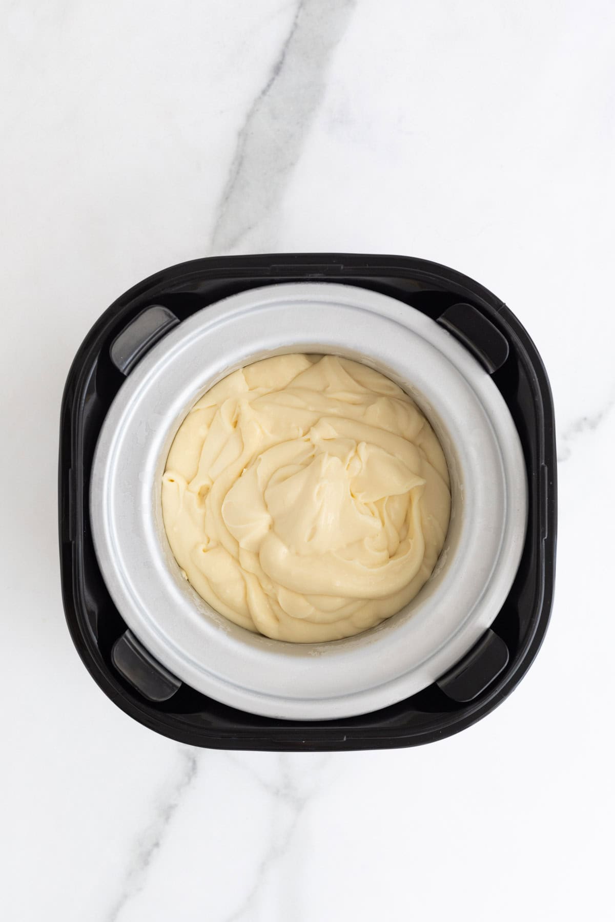 Thickened ice cream custard placed in a frozen bowl of an ice cream maker