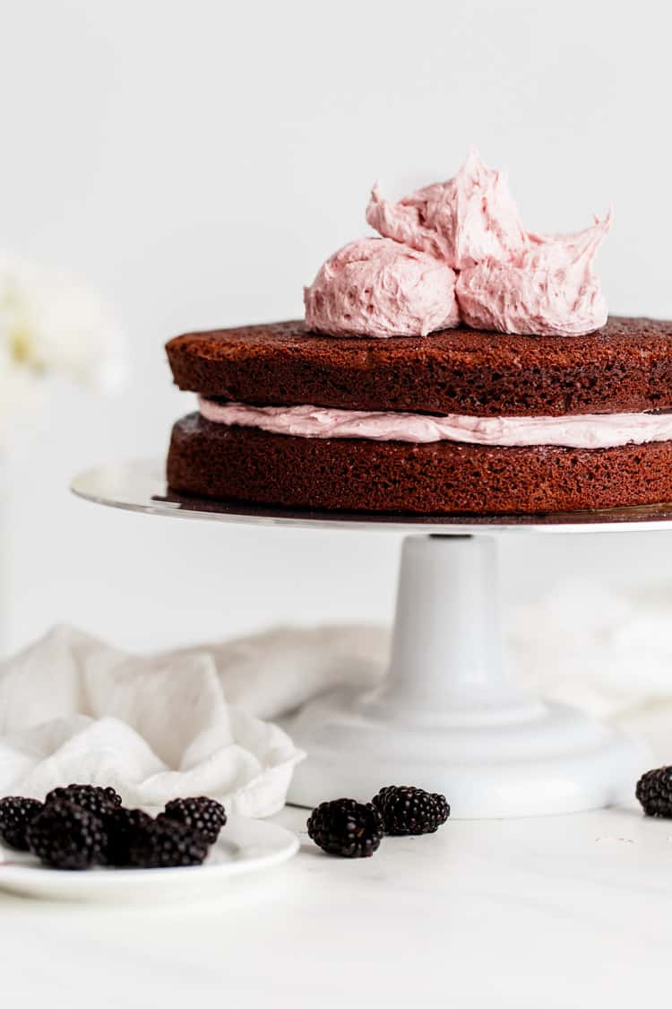 Two layers of the Best Chocolate Cake Recipe with Blackberry Buttercream about to be spread on top