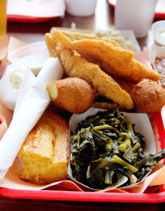 Close up of greens, cornbread, fried fish and hush puppies from Rodney Scott's in Charleston