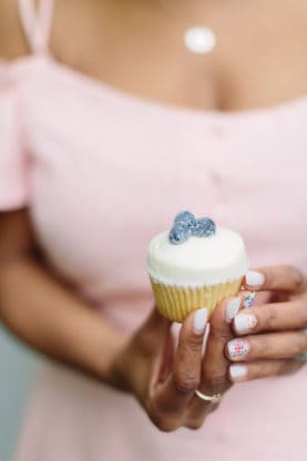 Jocelyn holding a tiny cupcake from Sugar BakeShop