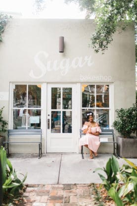 Jocelyn sitting on a bench outside Sugar Bakeshop in Charleston