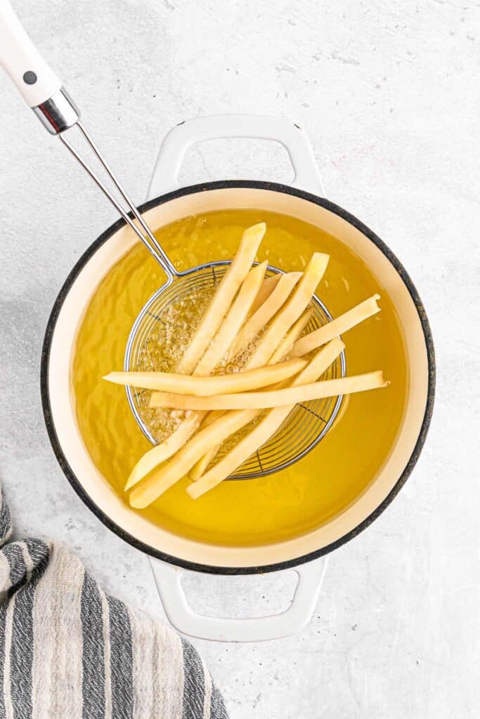 Cooking the french fries in oil.