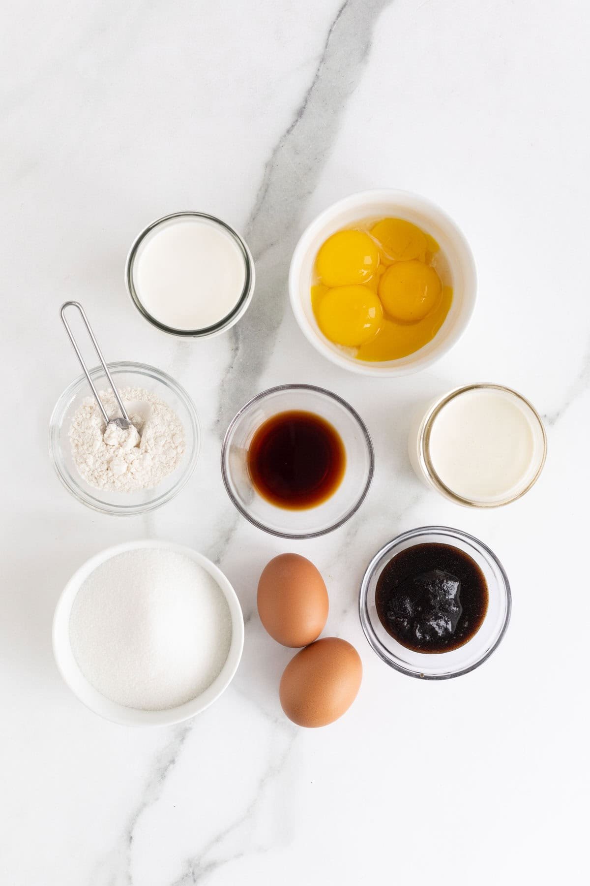 Overhead shot of ingredients for making homemade vanilla ice cream on a marble surface before mixing