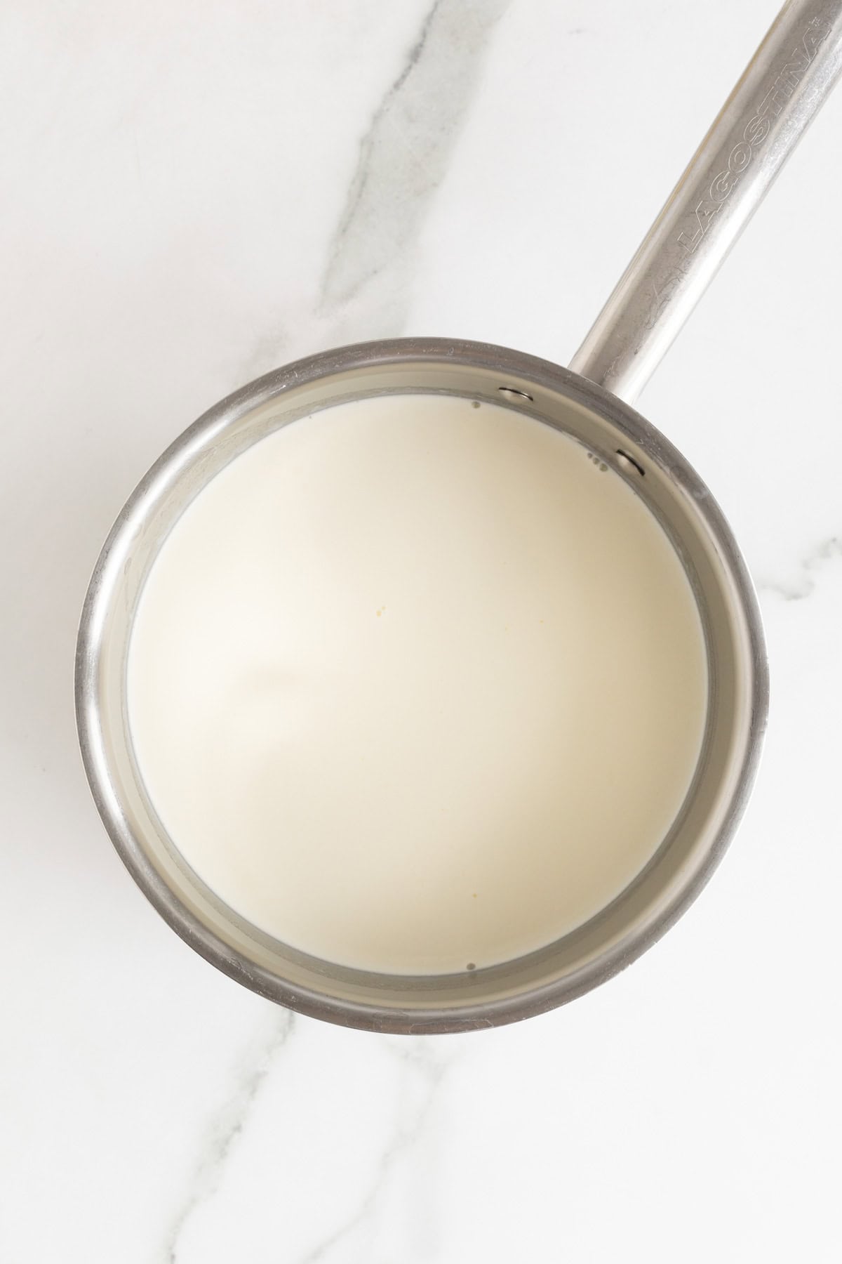 A saucepan filled with cream and half and half, just beginning to heat