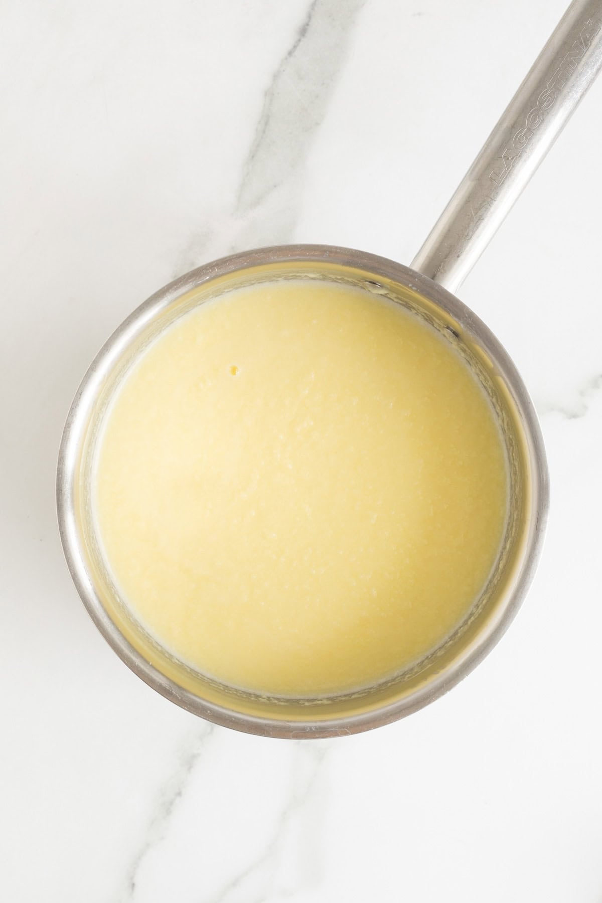 A saucepan filled with a yellow ice cream custard base, freshly cooked