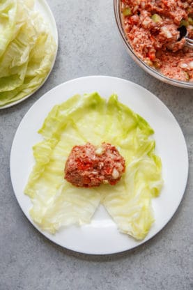 Overhead shot of a cabbage roll being stuffed with meat filling