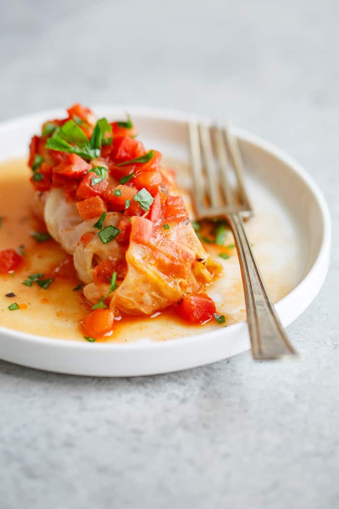 Stuffed Cabbage sitting on a white plate with a fork