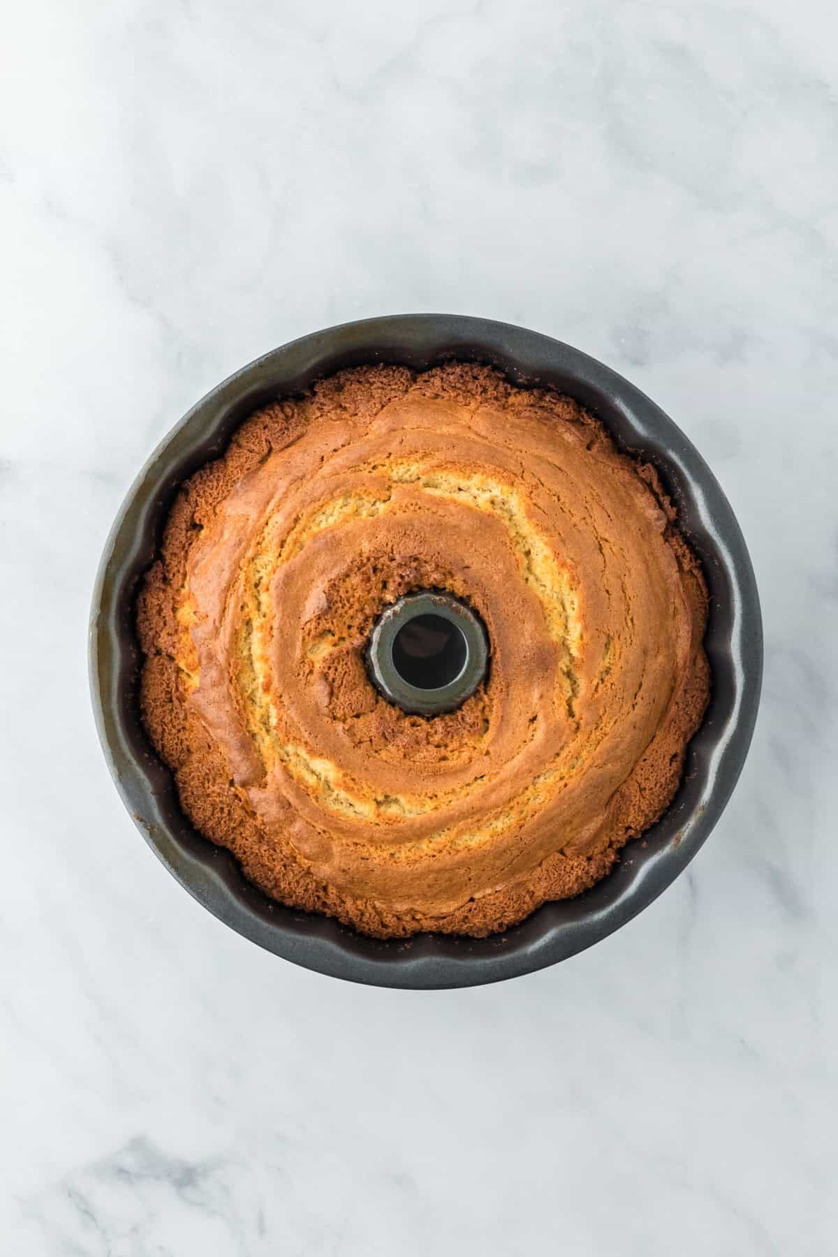 Baked sweet potato cake in a bundt pan on a white countertop