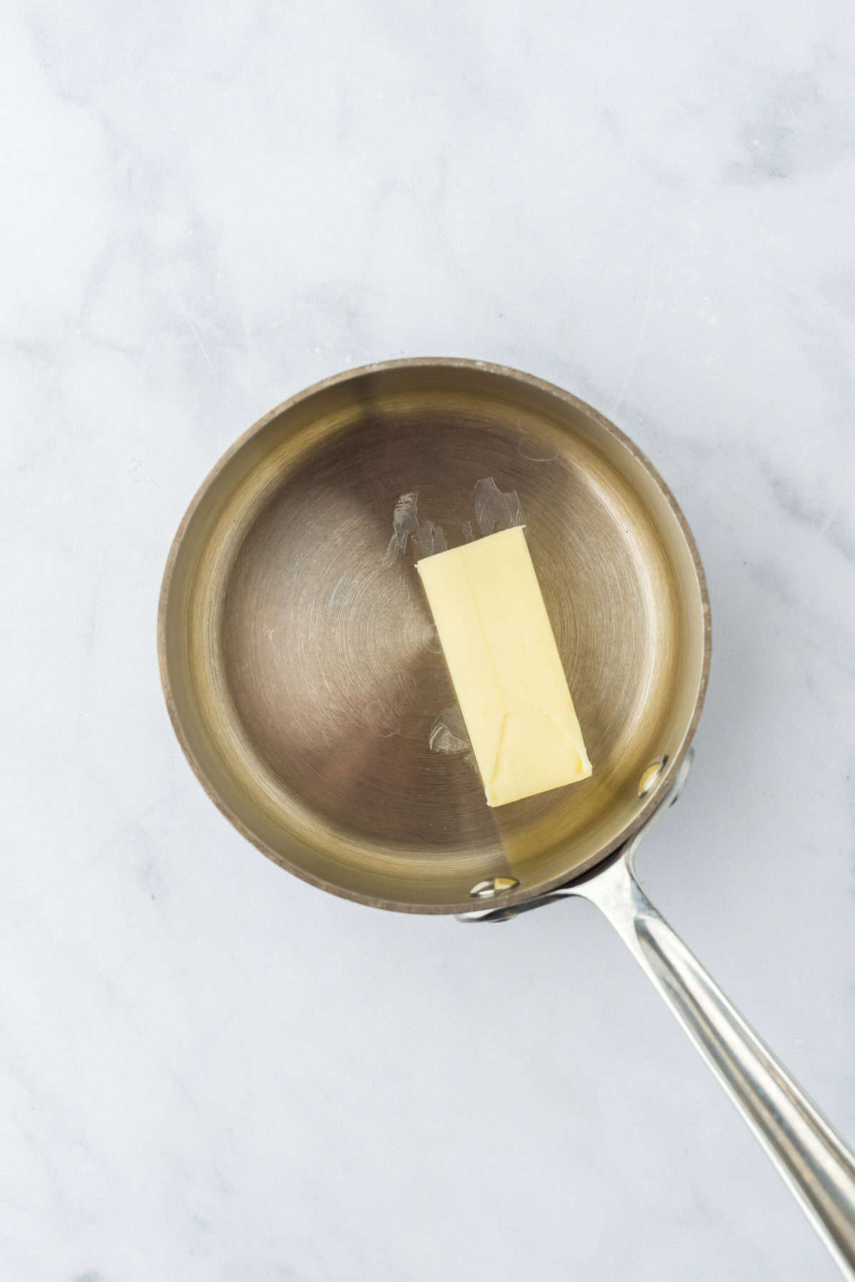 Butter in a saucepan on a white countertop