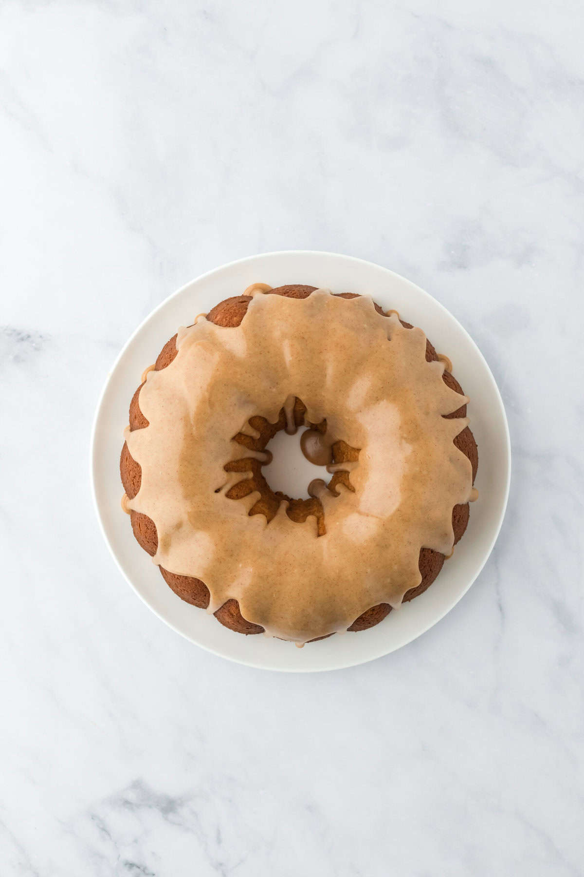 Completed sweet potato pound cake recipe with brown butter glaze on top on white countertop