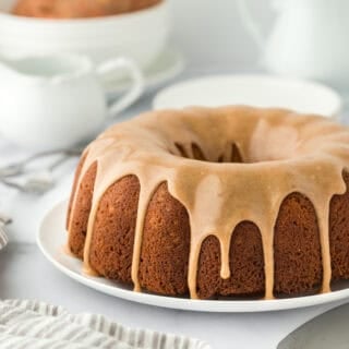 A large sweet potato pound cake recipe on a white plate with a white striped napkin with a white background