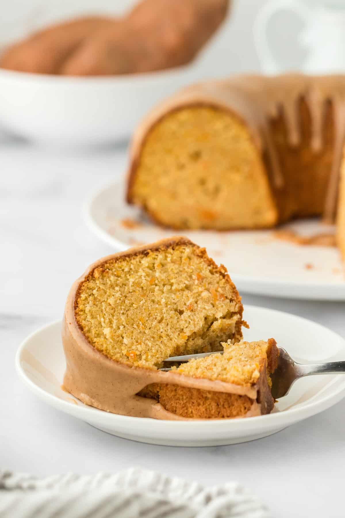 A slice of sweet potato pound cake recipe on a white plate with a fork going through it