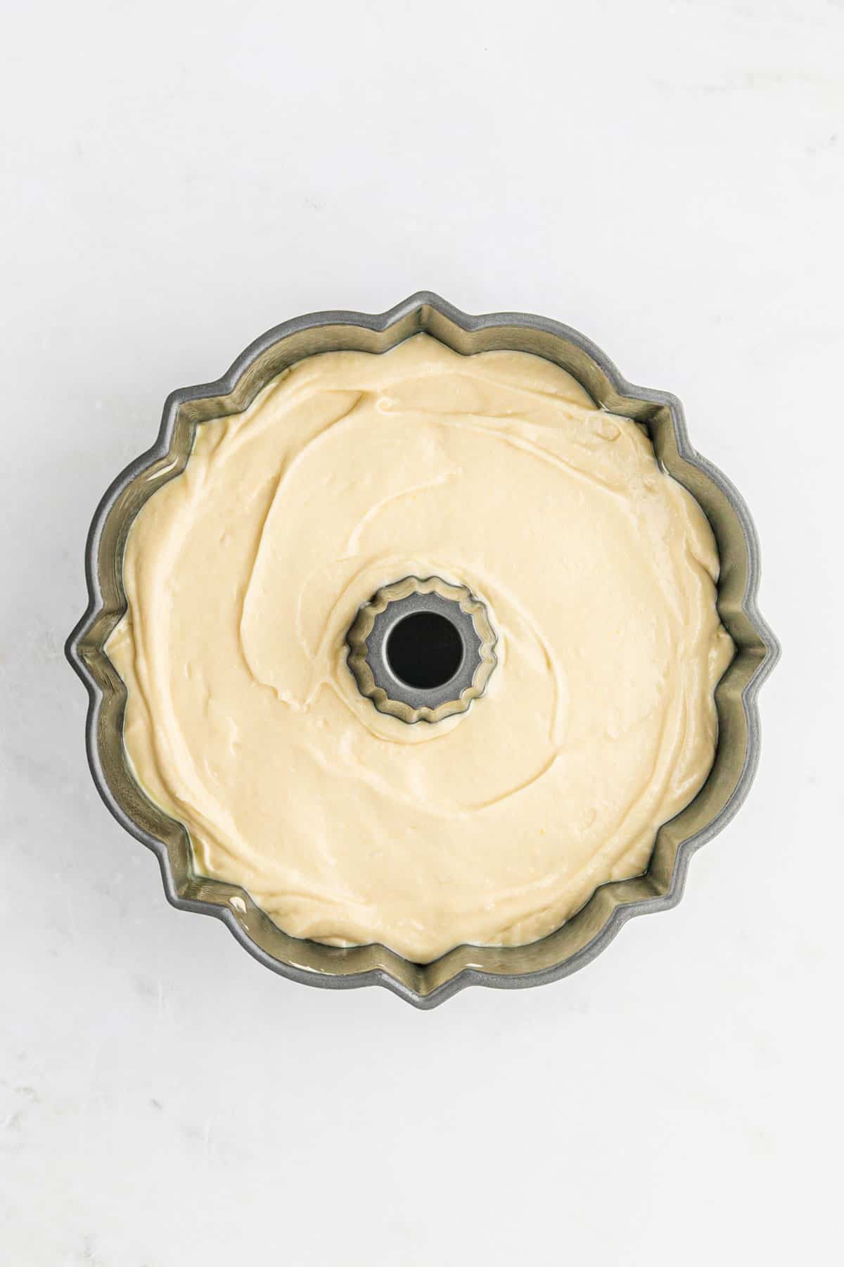 Sour cream pound cake batter poured into a bundt pan.