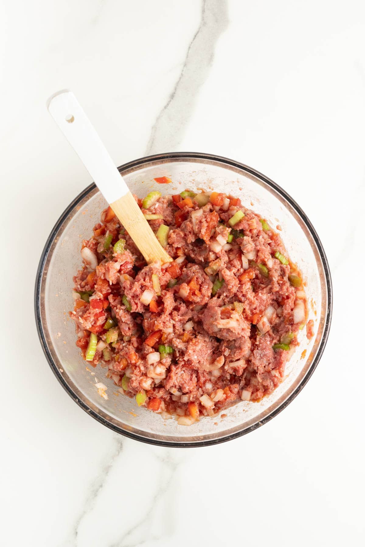 Meat mixture stirred together in glass bowl