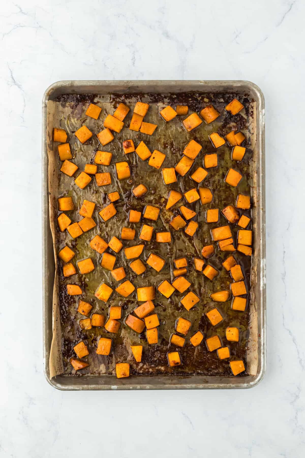 Roasted butternut squash on a baking sheet pan after coming out of the oven