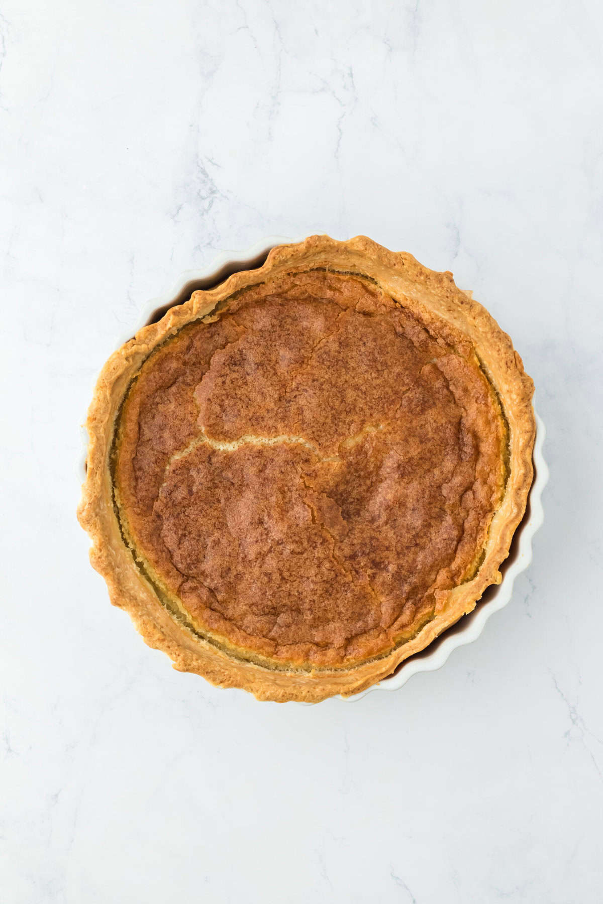 Baked buttermilk pie on white countertop.