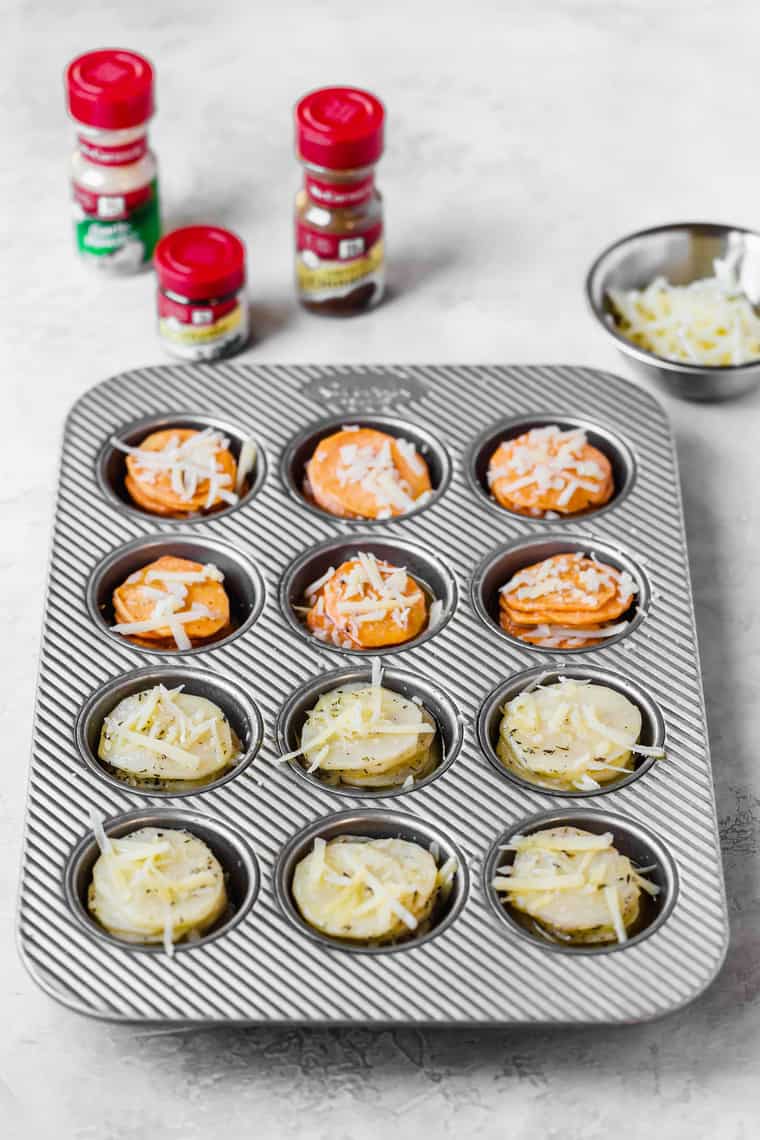 Sweet Potato and Yukon Gold potato slices in silver muffin pan preparing to bake