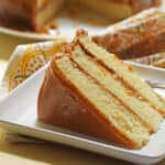 Slice of the best caramel cake recipe served on a white plate.