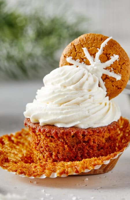 Perfect Gingerbread Cupcakes scattered against a white background with delicious buttercream piped high on each one