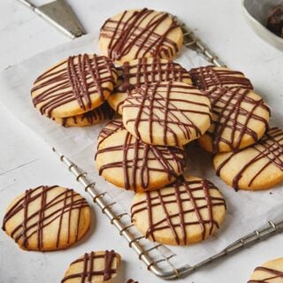 Shortbread cookies stacked on silver tray against white background