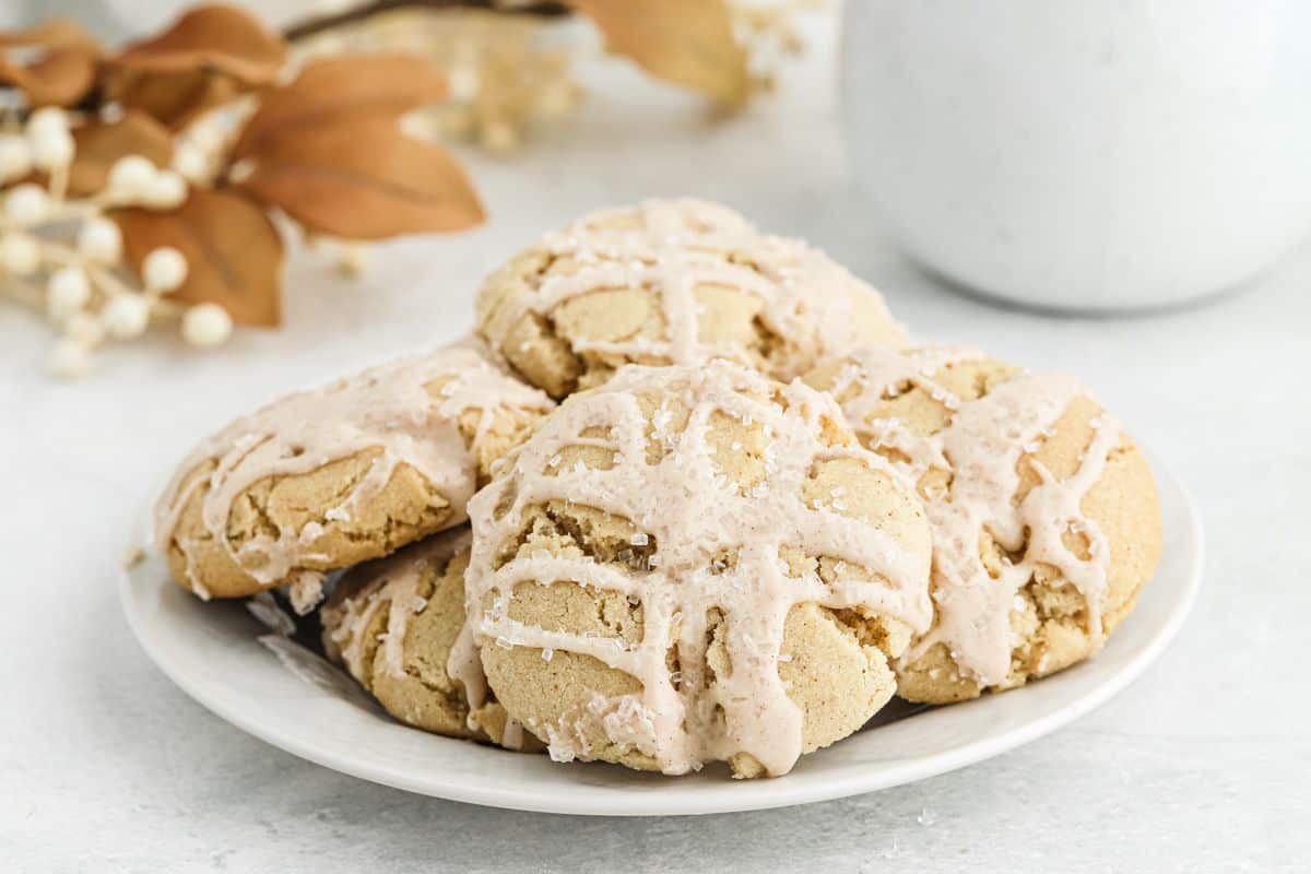 A plate of iced eggnog cookies on the table.