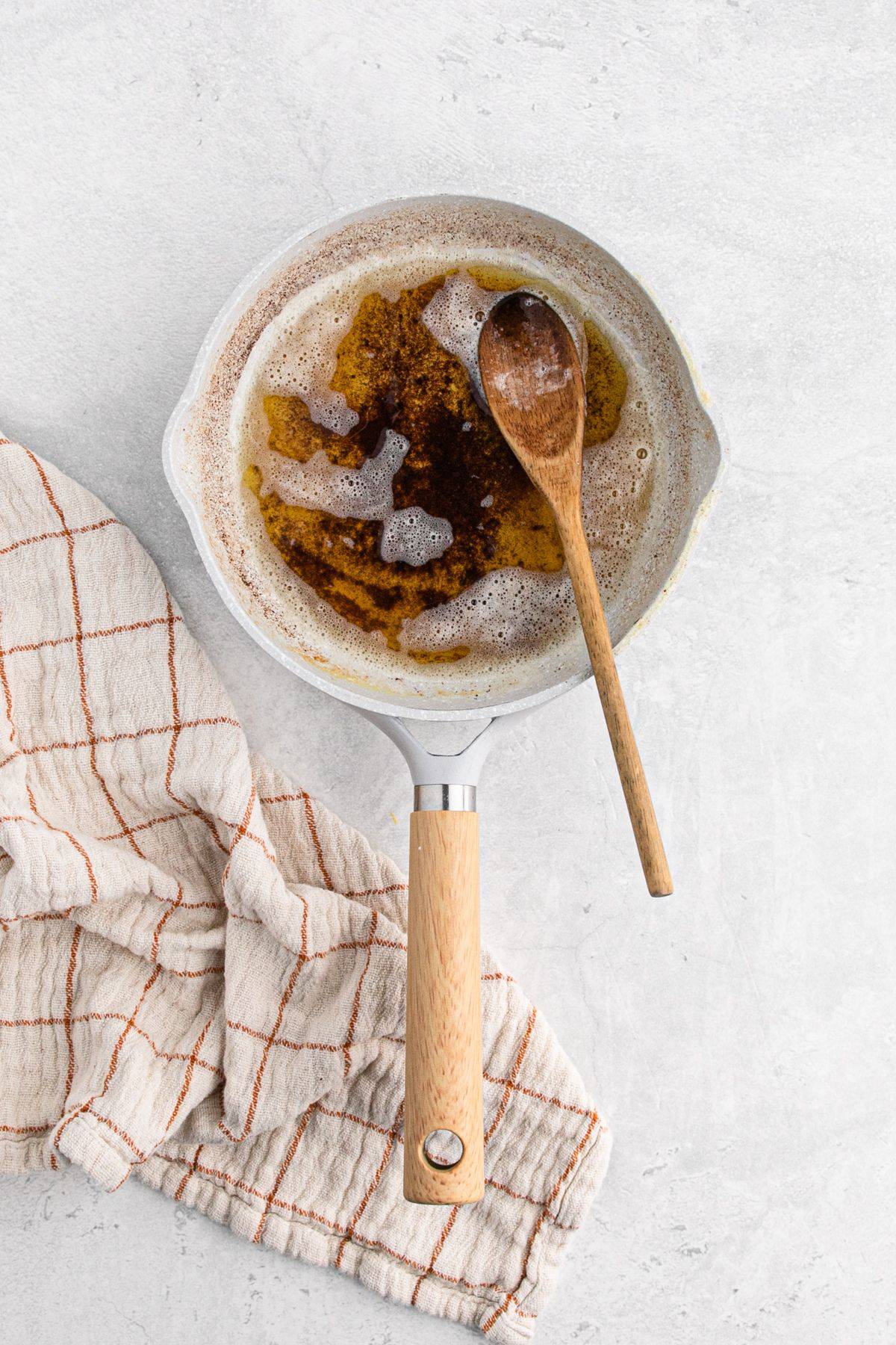 Browned butter in a saucepan with a wooden spoon in the pot.
