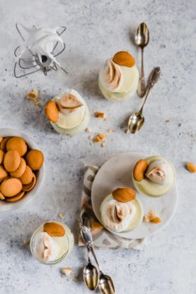 Overhead shot of homemade banana pudding in mini glasses with nilla cookies and meringue