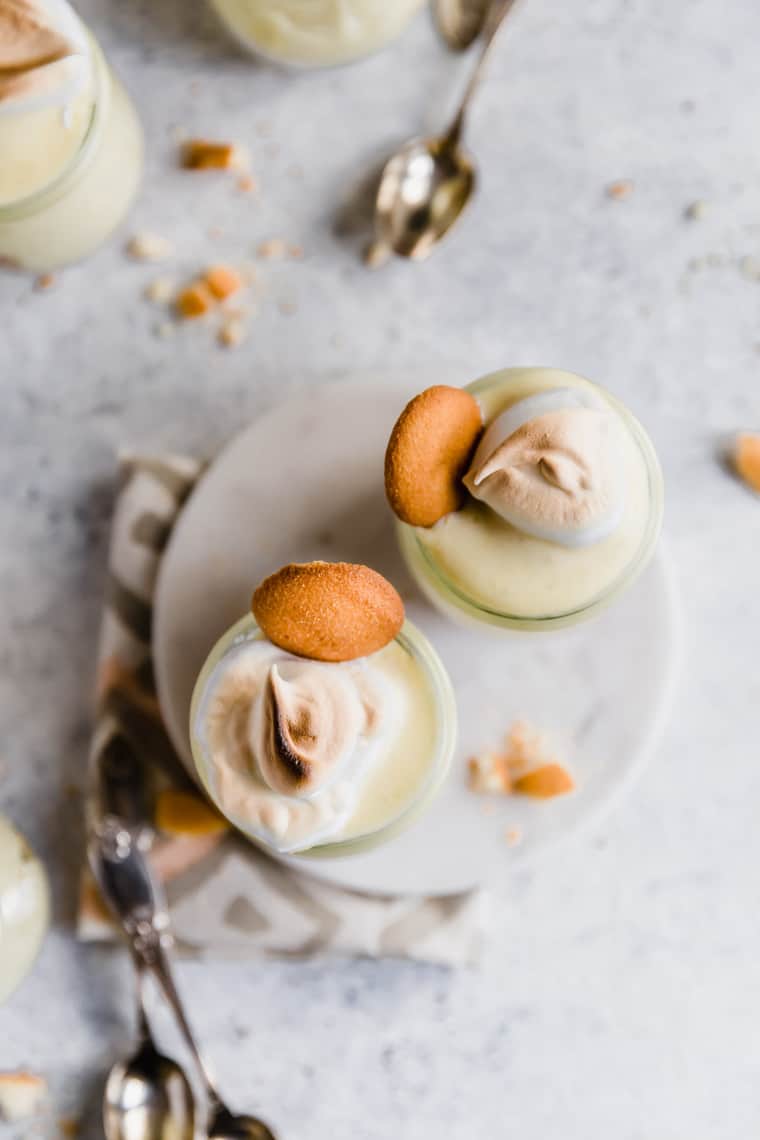 Overhead shot of two homemade banana pudding in mini glasses with nilla cookies and meringue