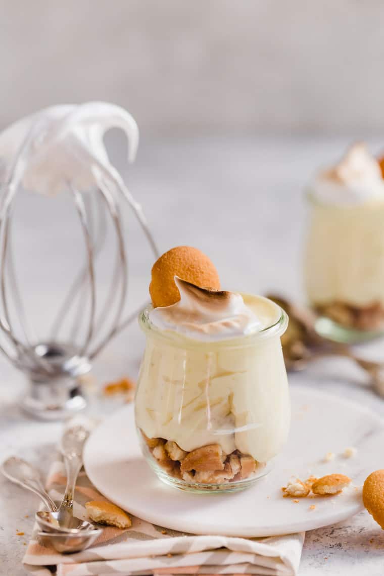 Straight on shot of homemade banana pudding in mini glasses with nilla cookies and meringue
