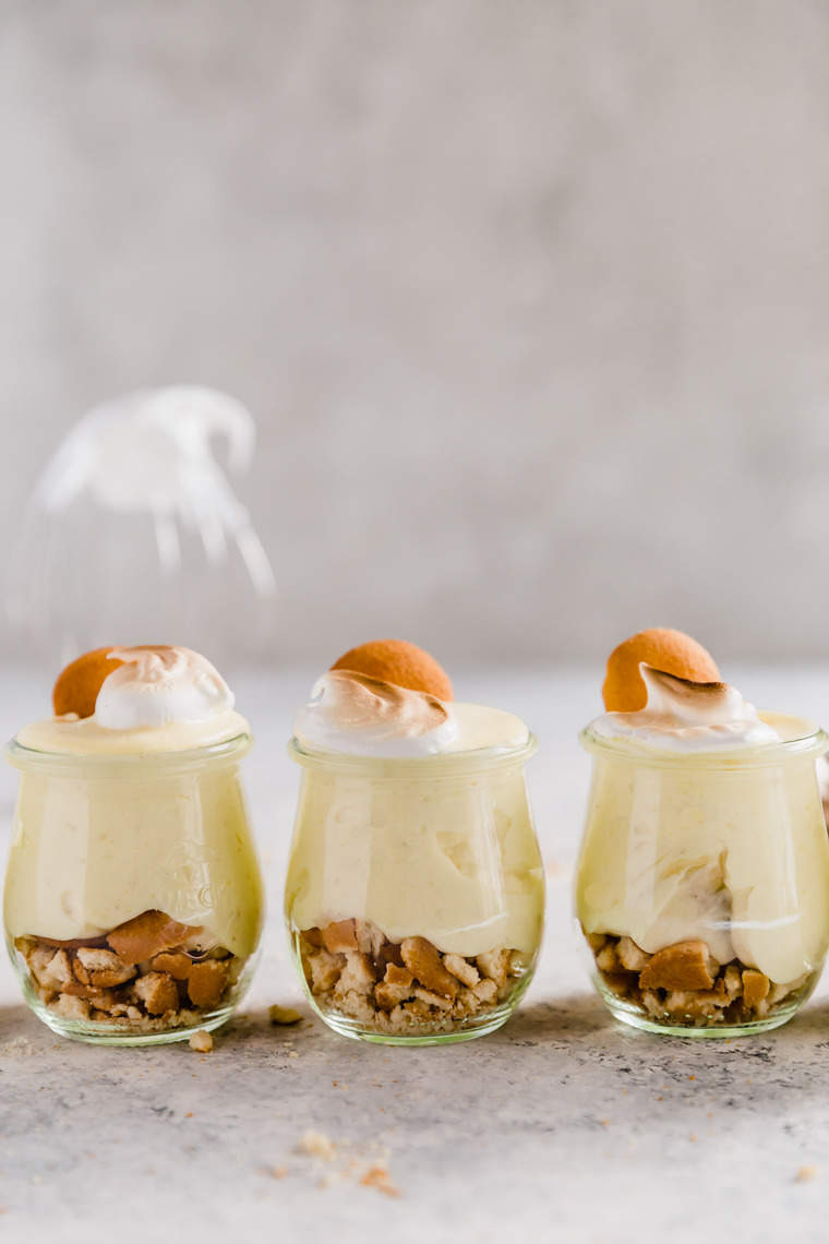Three homemade old fashioned banana pudding in small miniature glasses with wafer cookies. The best banana pudding recipe ever!