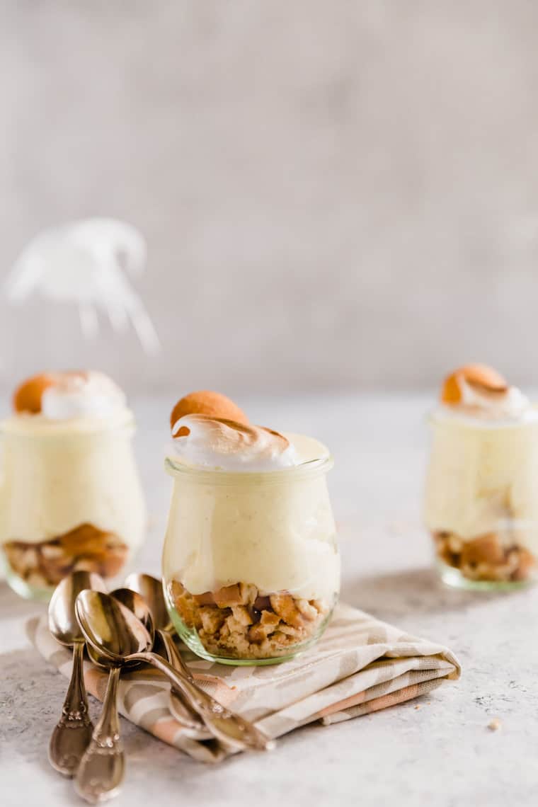 Three homemade old fashioned banana pudding in small miniature glasses with wafer cookies