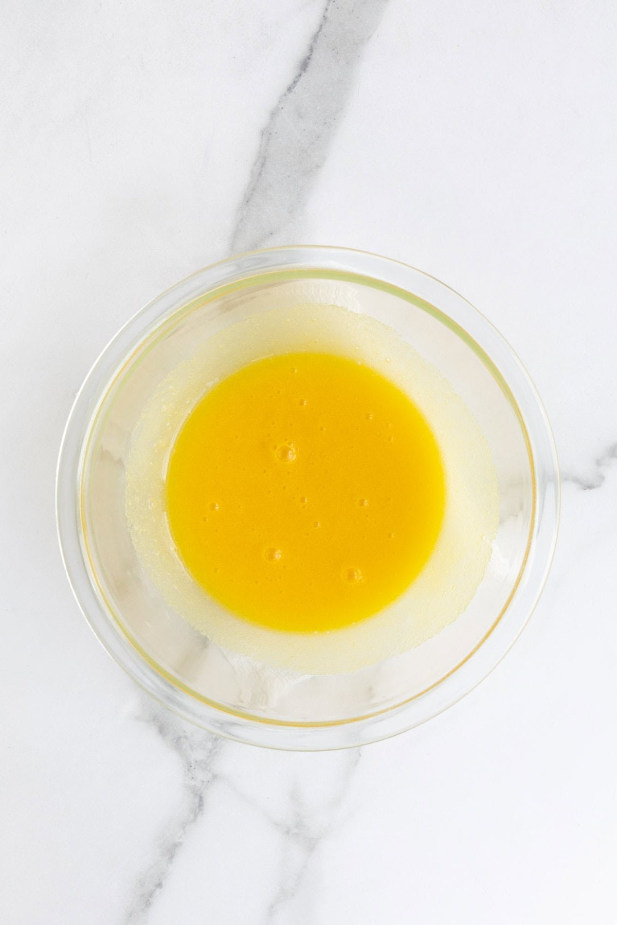 Whisked eggs and sugar in a glass bowl