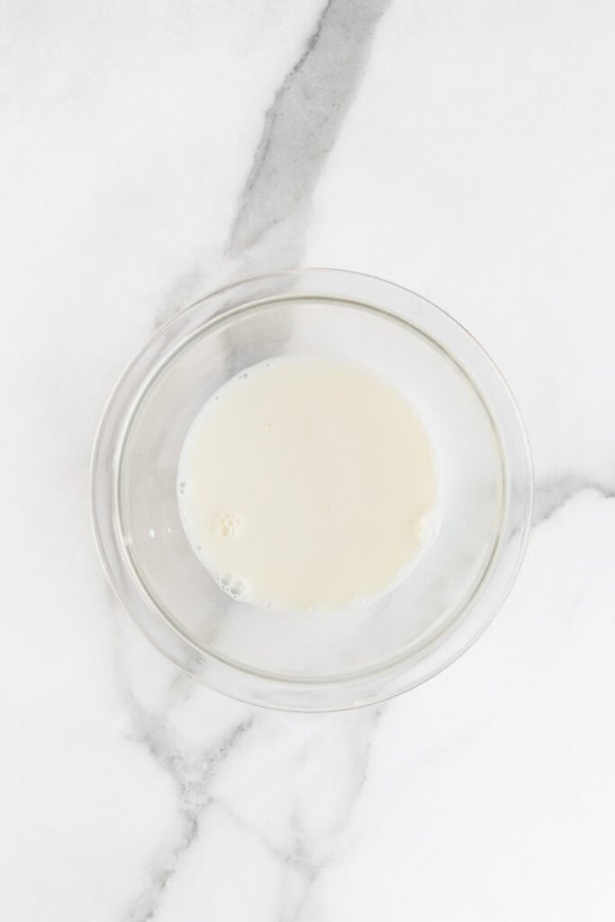 Cornstarch added to a glass bowl of milk