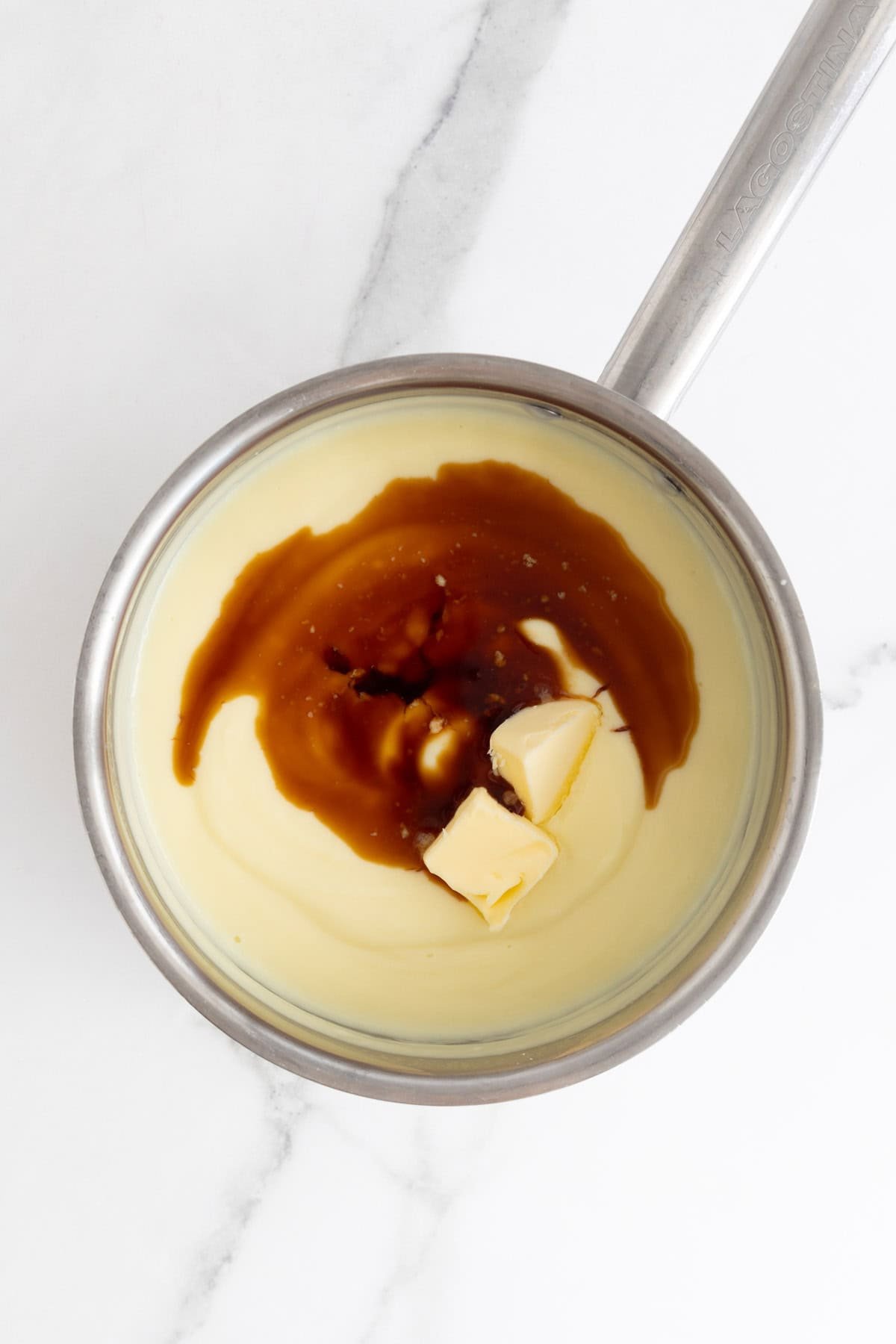 Vanilla and butter added to a thickened pudding in a pot