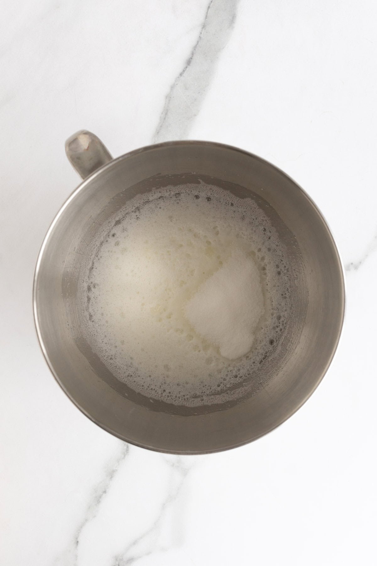 Egg whites being whipped in a mixing bowl