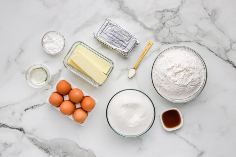 Ingredients to make a pound cake with cream cheese on the white counter.