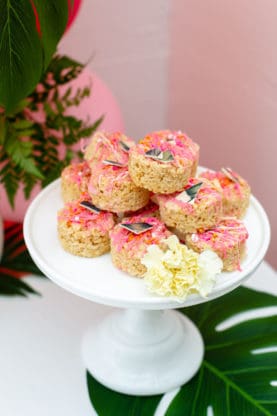 A white cake plate displaying rice krispy treats 