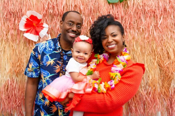 Jocelyn, Harmony and Jocelyn's husband at the baby's first birthday party Hawaiian Luau
