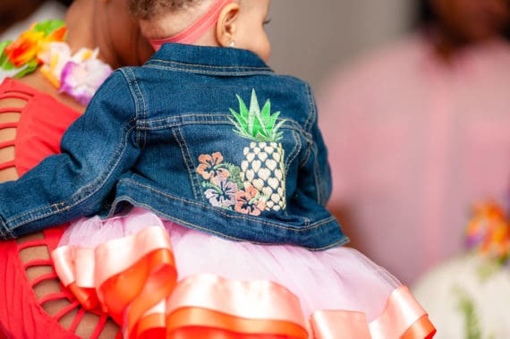 Harmony dressed in her blue jean jacket with a large pineapple and flowers on embroidered on the back