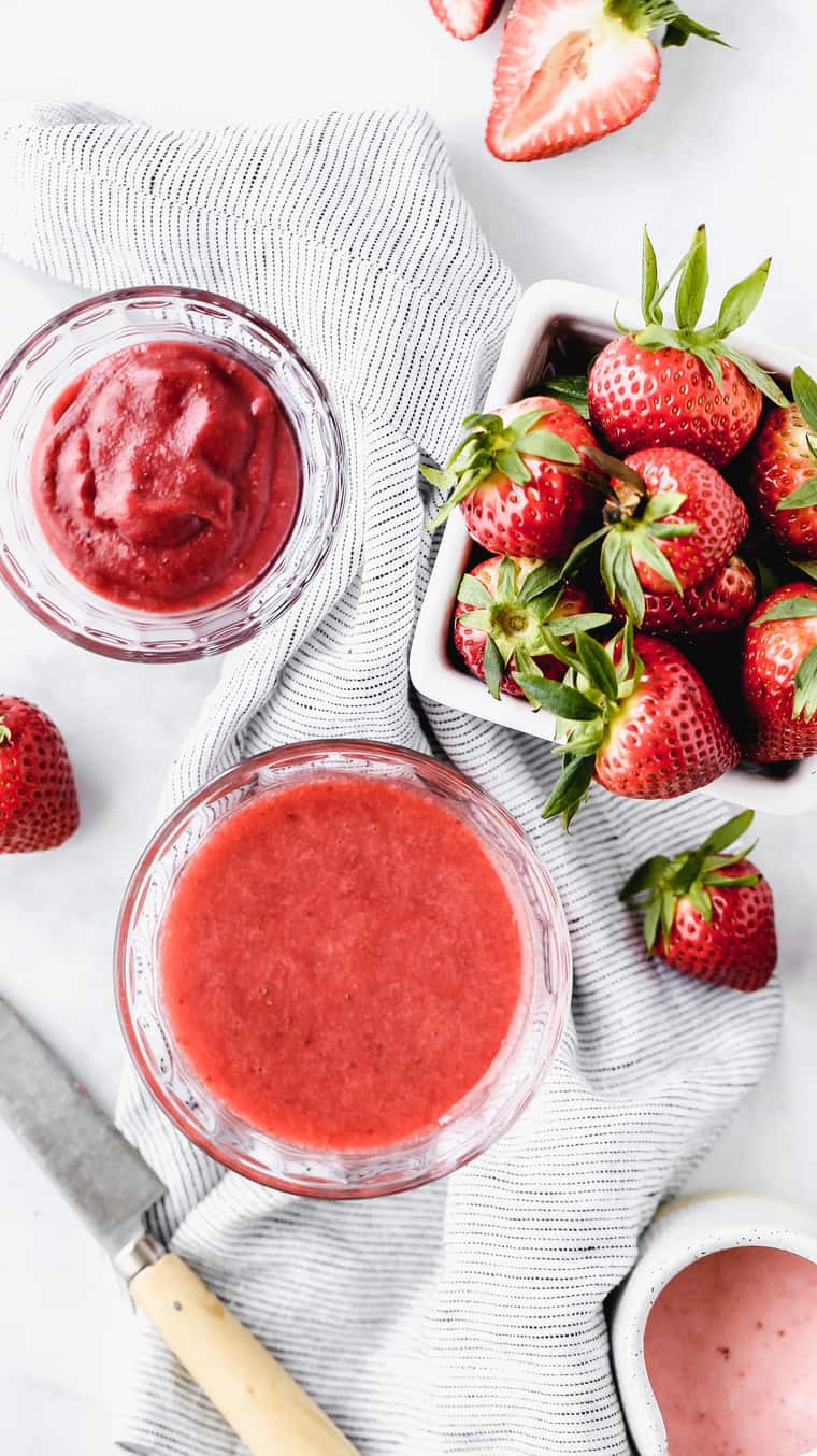 Overhead shot of fresh strawberry puree ready for Strawberry Cake along with a basket of fresh strawberries