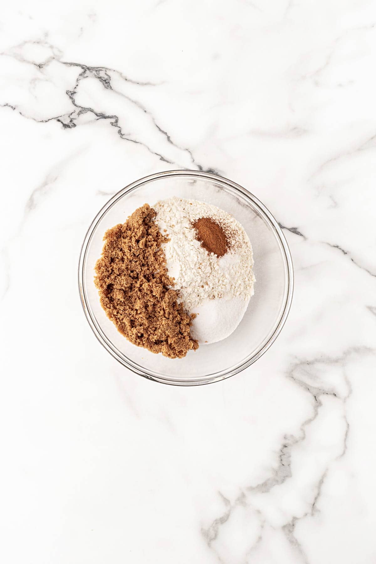 Bowl with flour, brown sugar, white sugar, and cinnamon for crumble topping